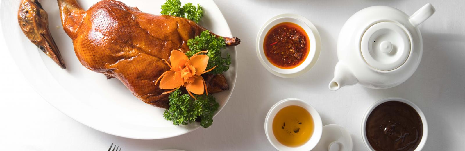 Pecking Duck and side sauces with tea at Yu Chu Chinese Authentic Restaurant - InterContinental Saigon in the center of district 1, Ho Chi Minh City. Try Cantonese cuisine with dim sum, pecking duck in luxury and modern style with skilled chef.